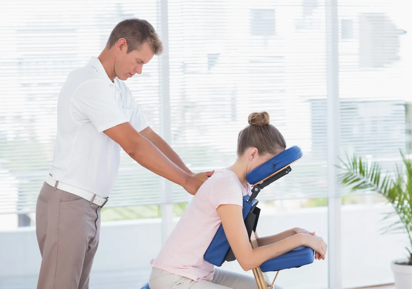 A chiropractor treating a patient in a busy local clinic