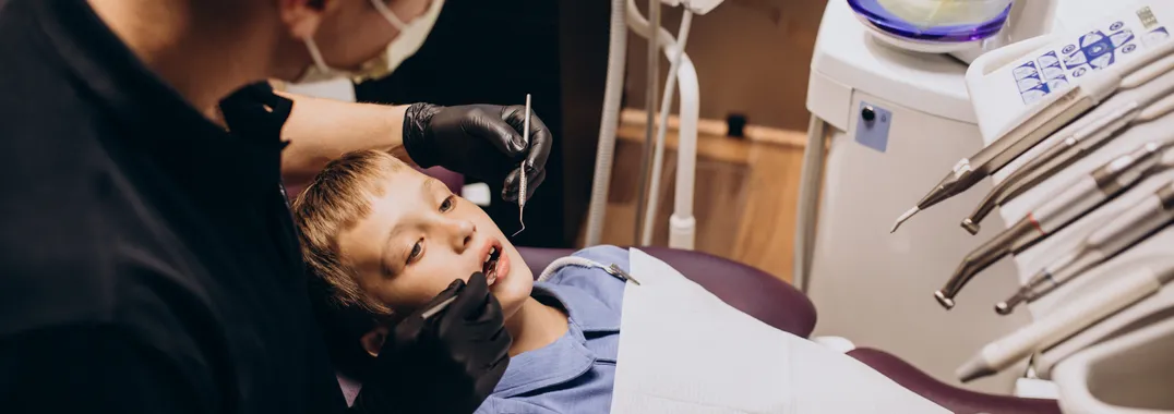 Pediatric dental exam in a clinic chair