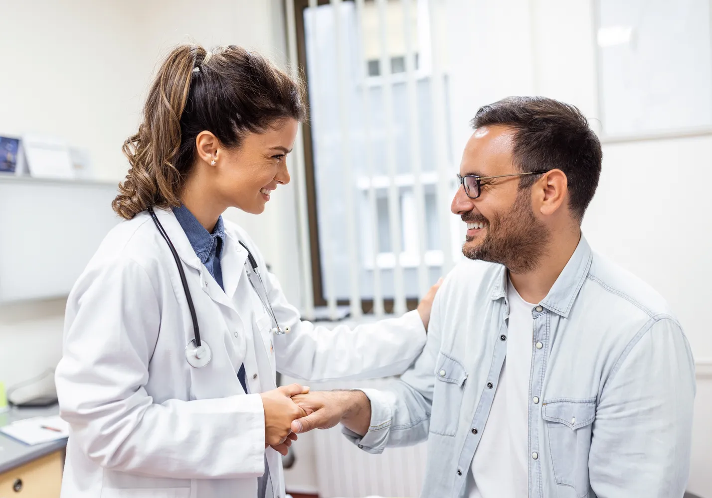 A clinician warmly reassuring a patient during a consultation